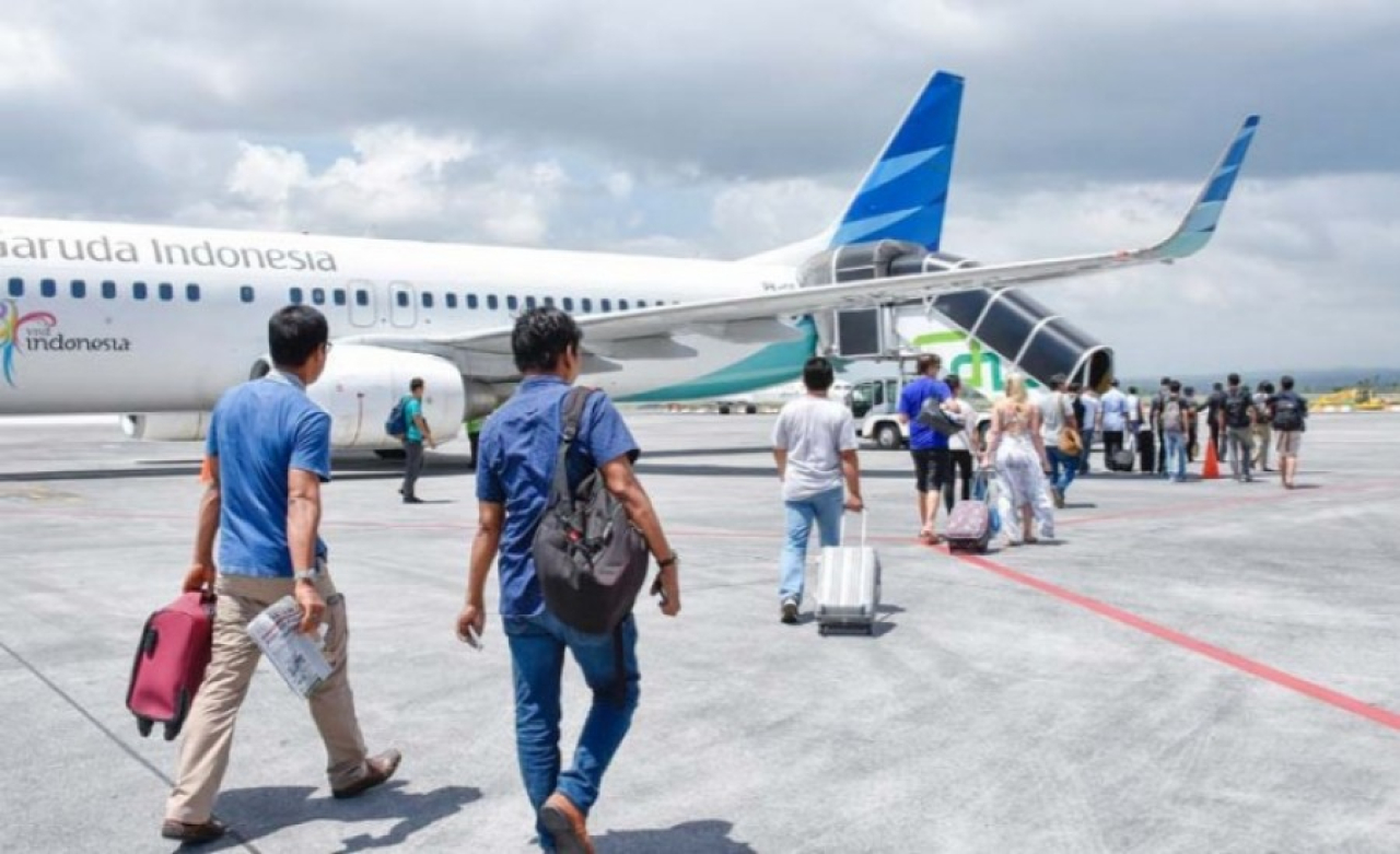 Penumpang hendak naik ke pesawat Garuda Indonesia