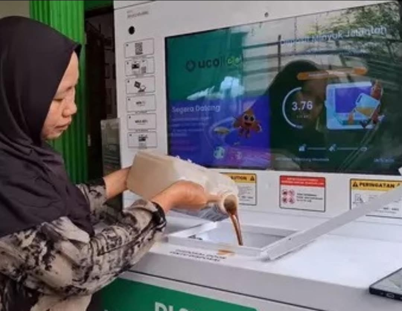 Konsumen mengisikan minyak jelantah ke dalam Mesin otomatis bernama UCOllect Box