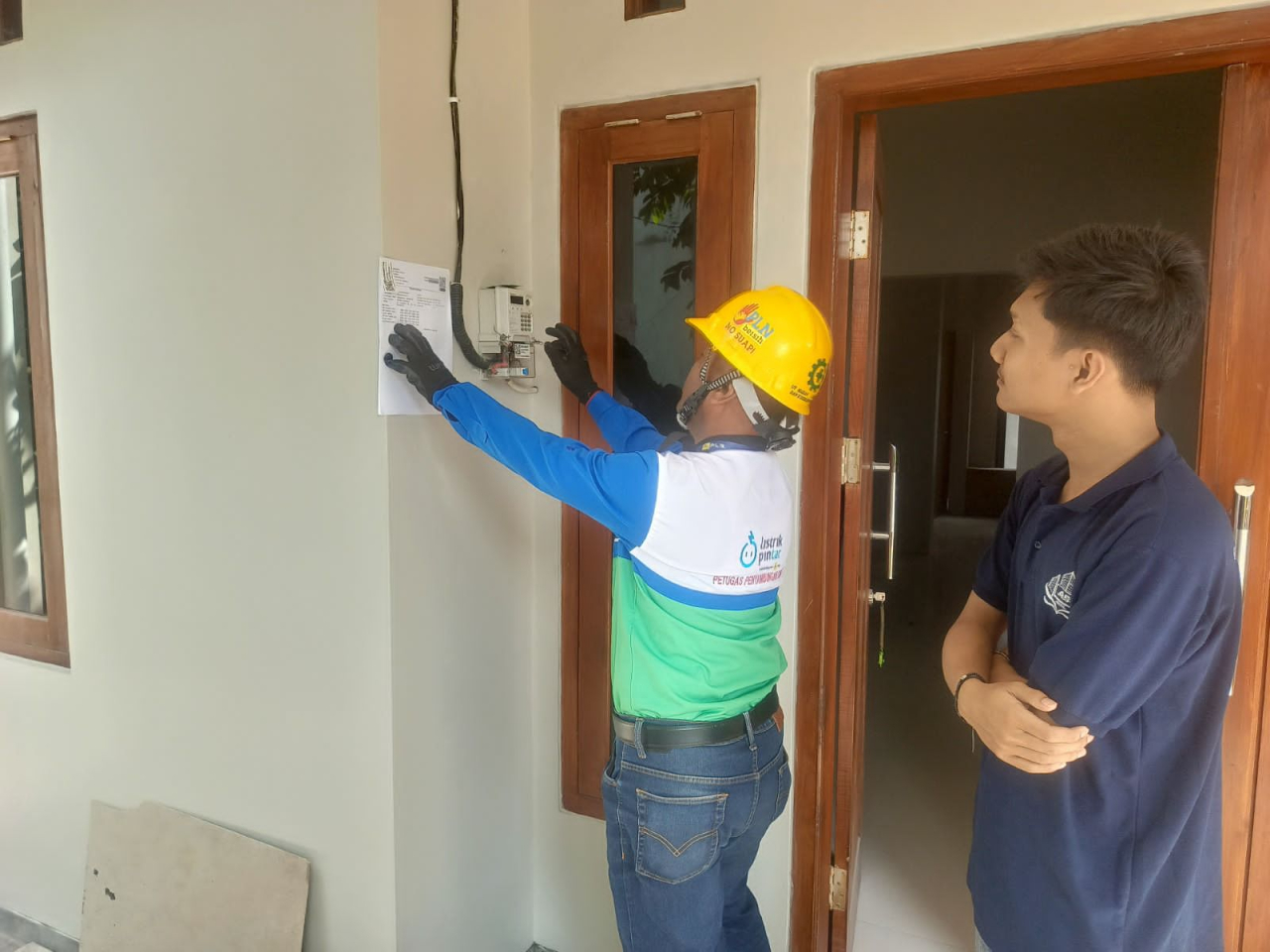 Petugas PLN melakukan proses penambahan daya listrik di rumah pelanggan