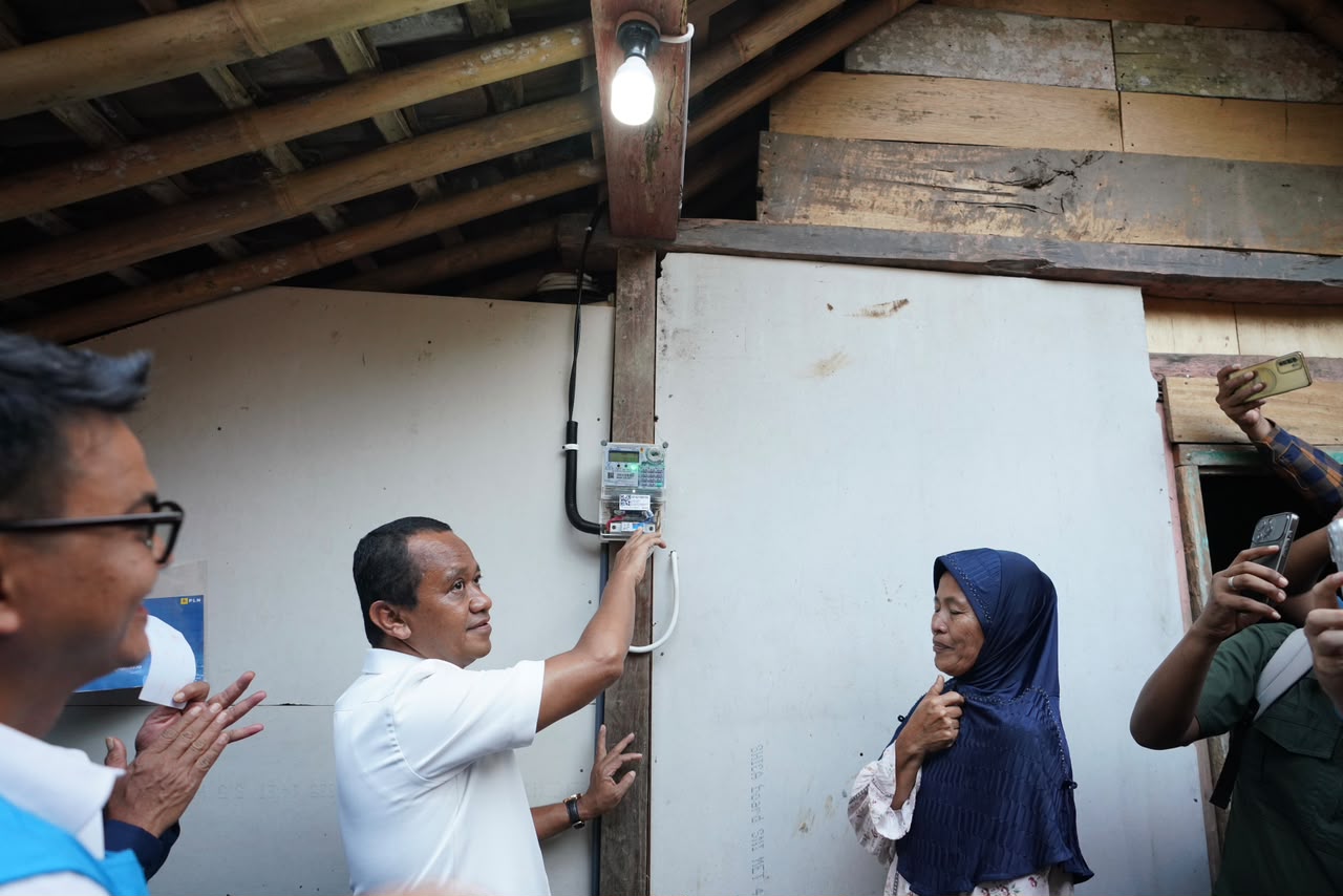 Menteri Energi dan Sumber Daya Mineral (ESDM), Bahlil Lahadalia (kedua dari kiri) saat melakukan penyalaan simbolis listrik di rumah salah satu penerima manfaat Program Bantuan Pasang Baru Listrik