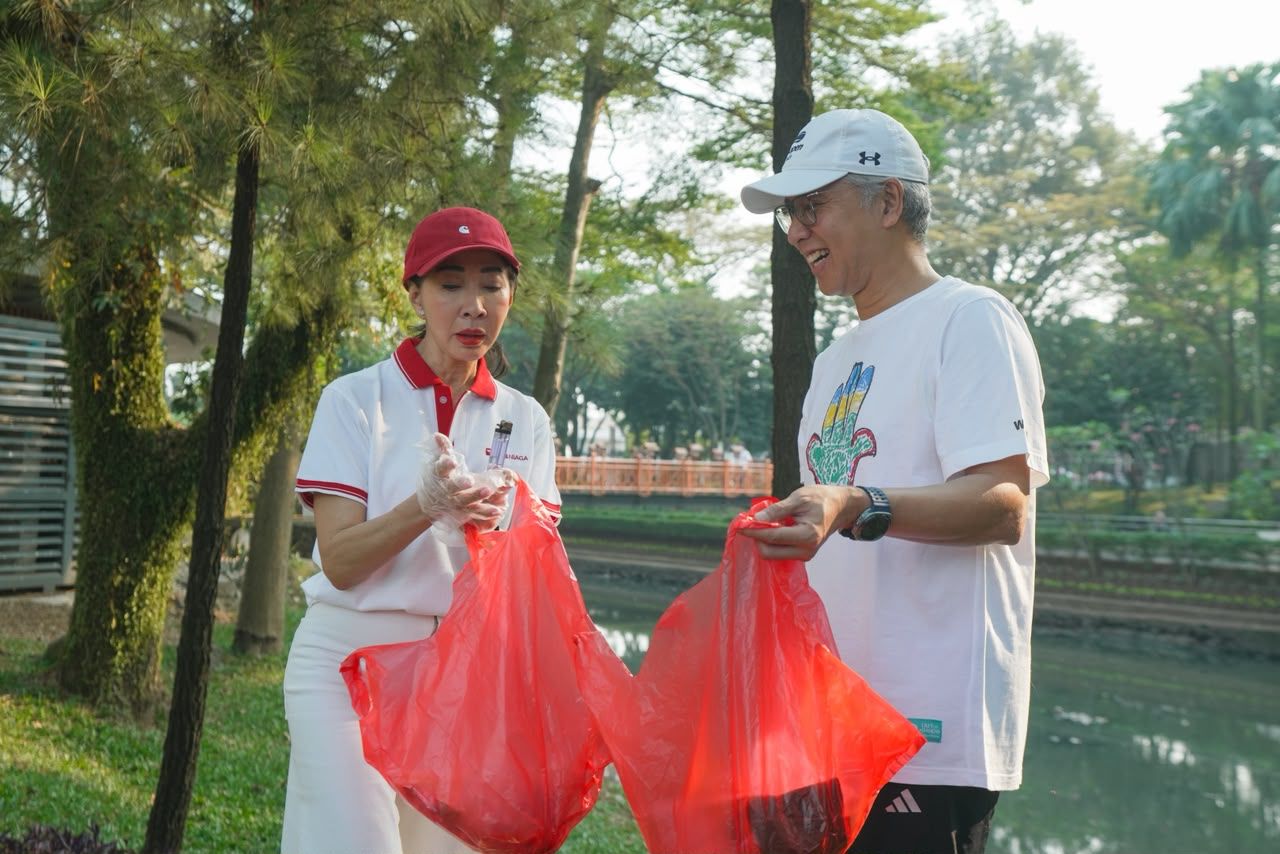 Direktur Compliance, Corporate Affairs & Legal CIMB Niaga Fransiska Oei (kiri) bersama Direktur Risk Management CIMB Niaga* Henky Sulistyo* (kanan) ikut membersihkan sampah